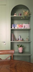 Cocina verde abierta al salón con mobiliario de formas curvas en Poble Sec.