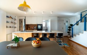 Cocina abierta al salón con suelo colorido y vistas al mar en Sitges.