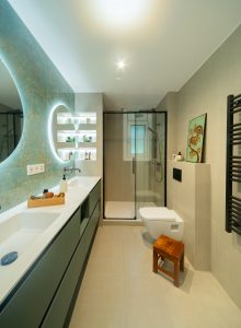 Baño suite con mueble doble verde y pared cerámica aguamarina estilo mar.