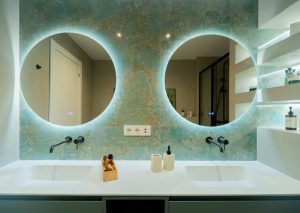 Baño suite con mueble doble verde y pared cerámica aguamarina estilo mar.