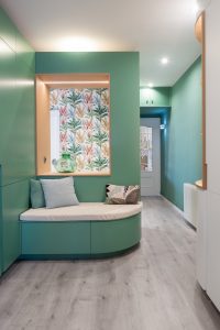 Recibidor con banco para calzarse y almacenaje oculto en vivienda de Sant Joan Despí.