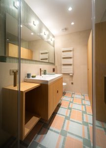 Baño de diseño contemporáneo del Proyecto Mallorca con acabados en tonos neutros, lavabo integrado y grifería elegante.